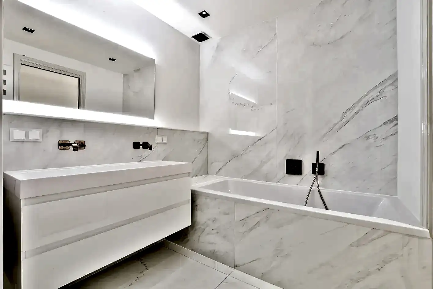 Beyaz mermer kaplama banyo, gömme küvet ve minimalist tasarım.