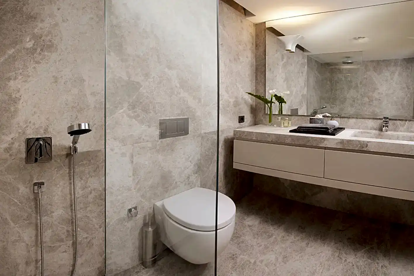 Mermer desenli modern banyo tadilatı ve cam duşakabin.