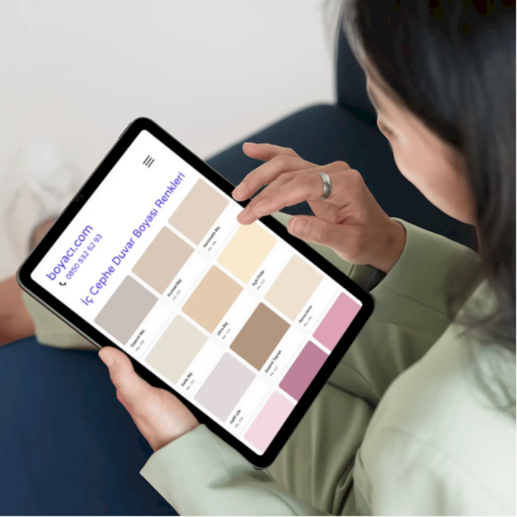 Online katalog üzerinden ev için yeni duvar rengi seçimi yapan kullanıcı.