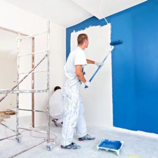 Rulo ile duvarı maviye boyayan profesyonel boya ustası