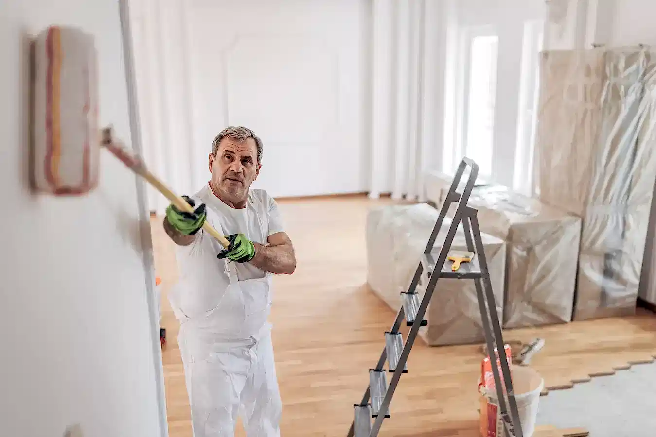 Rulo fırça ile iç cephe duvar boyası yapan usta